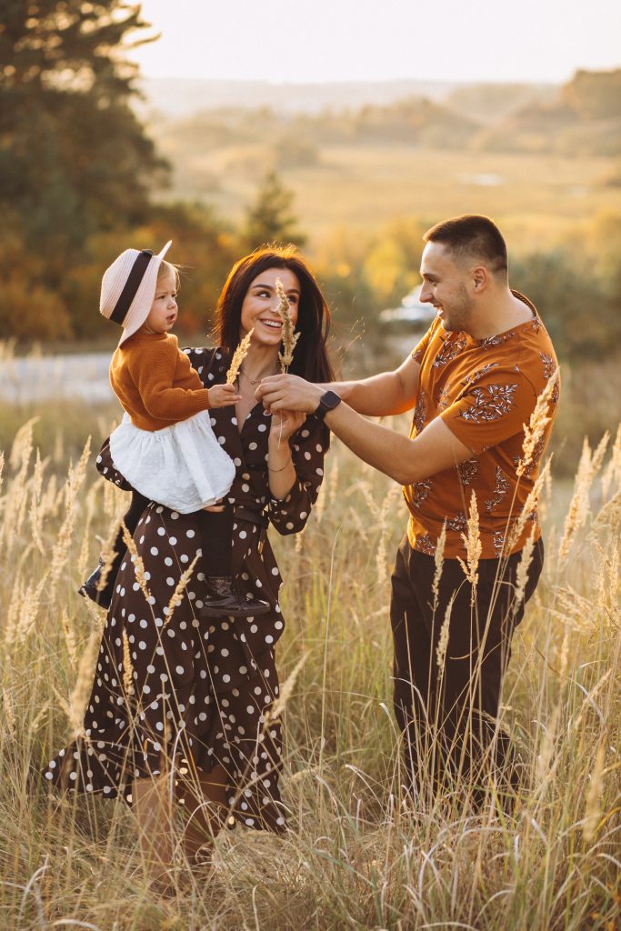 Family with their little daughter in an autumn field